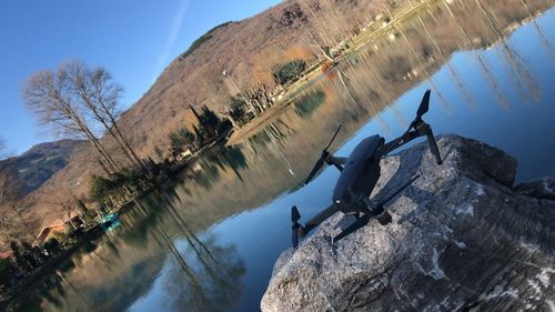 Tilt image of drone on rock by lake