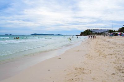 Group of people on beach against sky