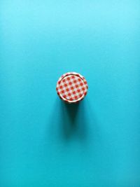 Directly above shot of marmalade jar on blue background