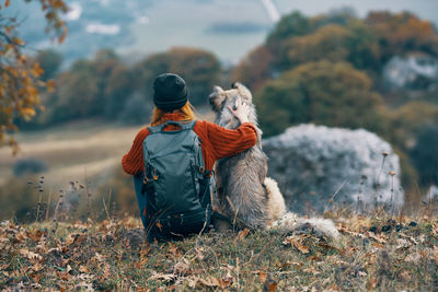 Rear view of man with dog on field