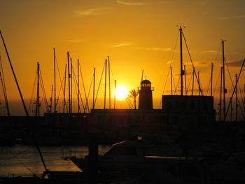 Silhouette of boats moored at sunset