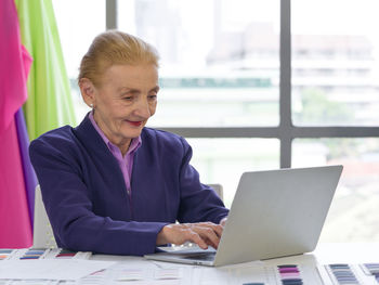 Woman using phone while sitting on table