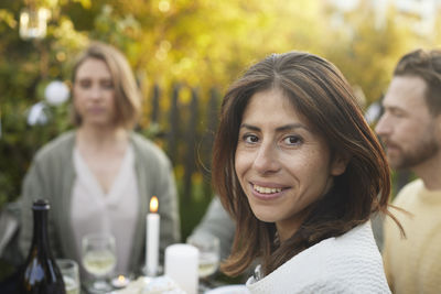 Smiling woman looking at camera during garden party