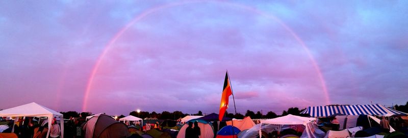 Panoramic view of people at rainbow against sky