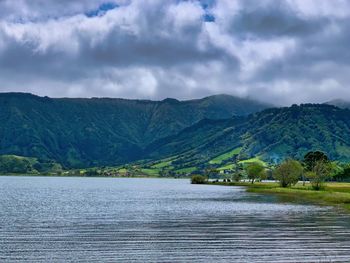 Scenic view of lake by mountains against sky