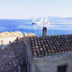 Sailboats on sea by building against sky