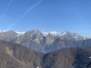 Scenic view of snowcapped mountains against blue sky