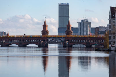 Arch bridge over river against sky in city