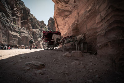 Abandoned truck on rock formation against sky