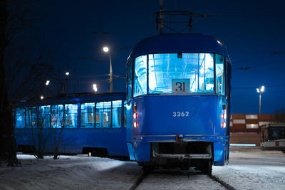 Blue car against sky at night during winter