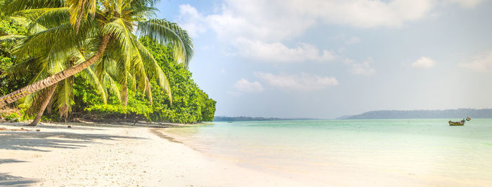 Scenic view of beach against cloudy sky