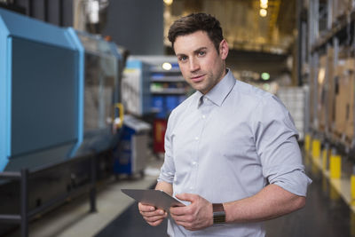 Portrait of man with tablet in factory warehouse