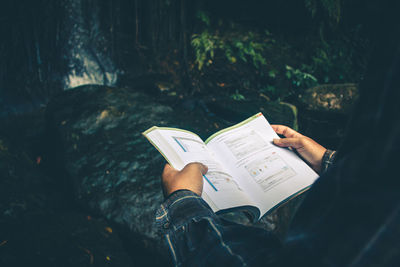 High angle view of hand holding book