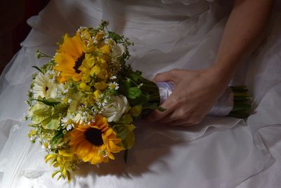 Midsection of person holding bouquet