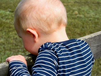 Close-up of boy standing by railing