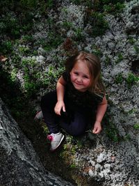 High angle portrait of girl sitting on field