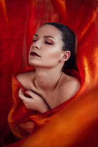High angle view of topless young woman with orange fabric