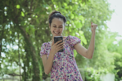 Young woman in yeah and satisfy emotion when her look at mobile phone