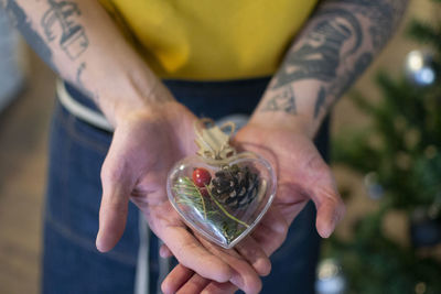 Midsection of man holding heart shape decoration