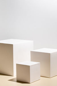 Scene with three white podiums on beige background