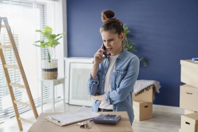 Young woman using mobile phone at table