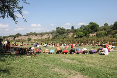 People kneeling and bending on grassy field during religious ceremony