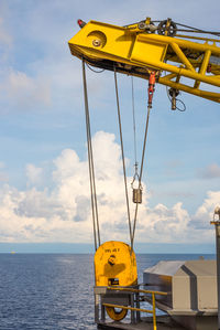 Yellow ship in sea against sky