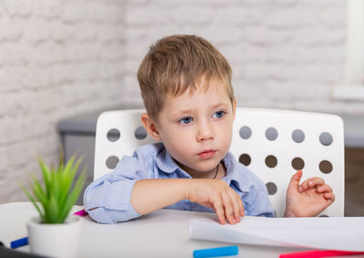 Portrait of boy sitting on table