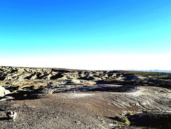 Scenic view of rocks against clear blue sky