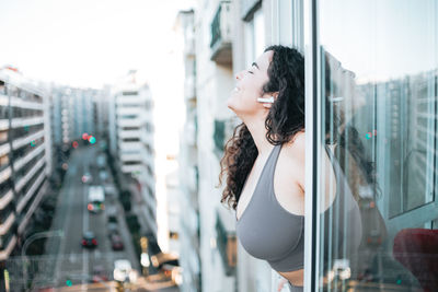 Young woman looking through window