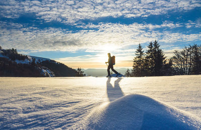 Man on snowy field against sky during winter