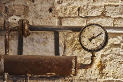 Close-up of gauge on old distiller against wall