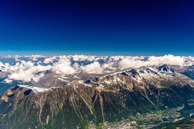 Scenic view of snowcapped mountains against blue sky