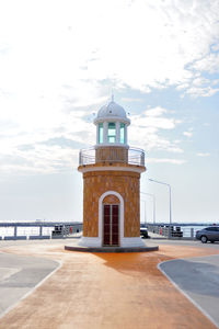 Lighthouse by sea against sky