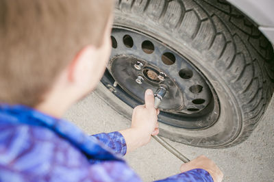 Cropped image of mechanic fixing car tire