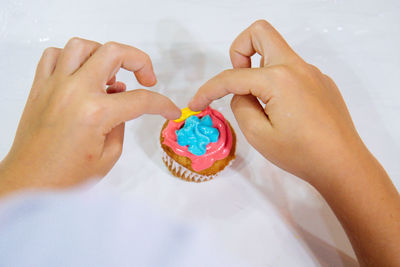 Midsection of person holding cupcake.