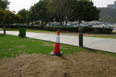 Road sign by trees in city
