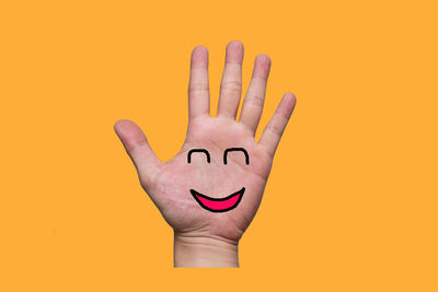 Close-up of human hand against yellow background