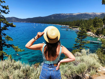 Rear view of woman in hat against mountains