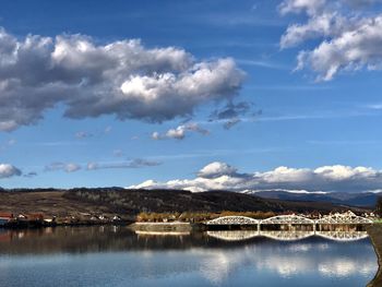 Scenic view of lake by buildings against sky