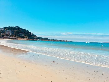 Scenic view of beach against blue sky