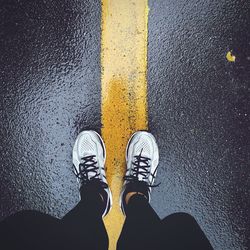 Low section of man standing on road