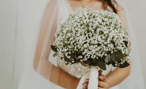 Portrait of a young unrecognizable caucasian bride with a bouquet of boutonnieres.