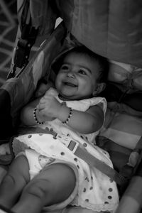 Portrait of cute baby girl lying on bed