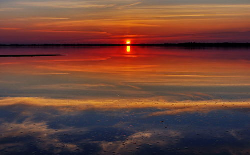 Scenic view of sea against dramatic sky during sunset