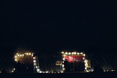 People standing on illuminated street at night