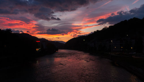 Illuminated road against sky during sunset