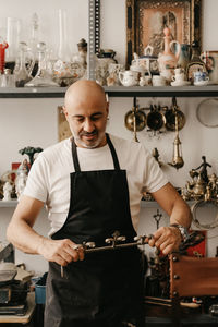 Man smiling while standing at shop