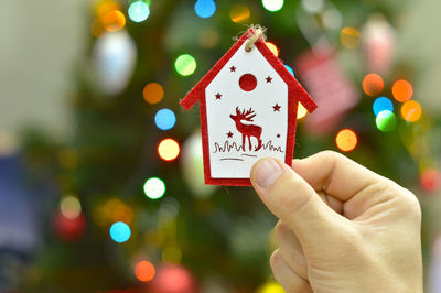 Hands decorating christmas tree with bauble, new year decoration