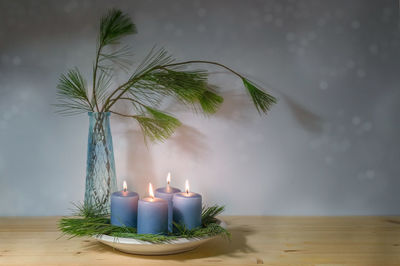 Close-up of illuminated candle on table